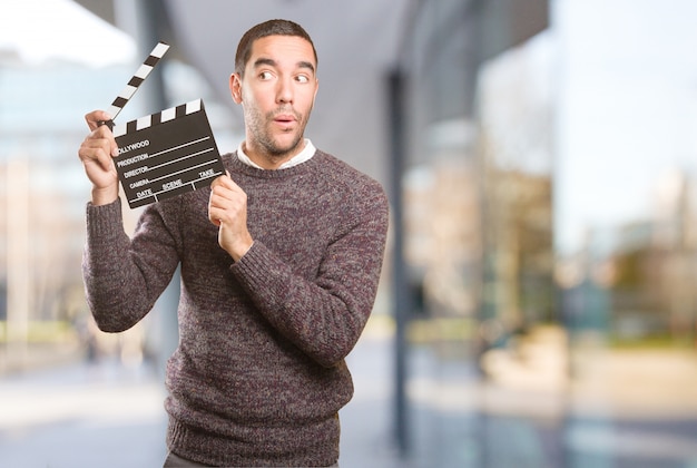 Foto hombre joven divertido que usa una claqueta