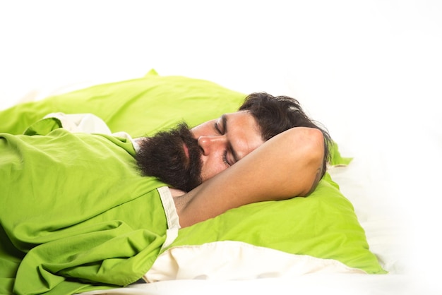 Hombre joven durmiendo en la cama Dormir tranquilamente tranquilamente Hombre durmiendo sobre una almohada en la cama en casa Concepto de hombre de siesta