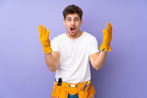 Hombre joven electricista con expresión facial sorpresa