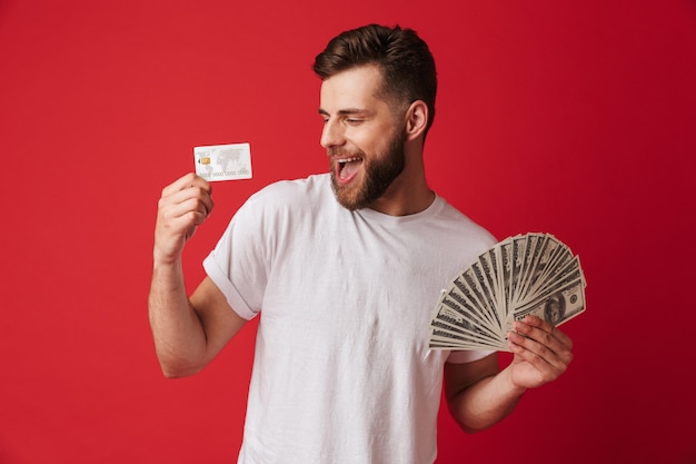 Hombre joven emocionado con dinero y tarjeta de crédito.