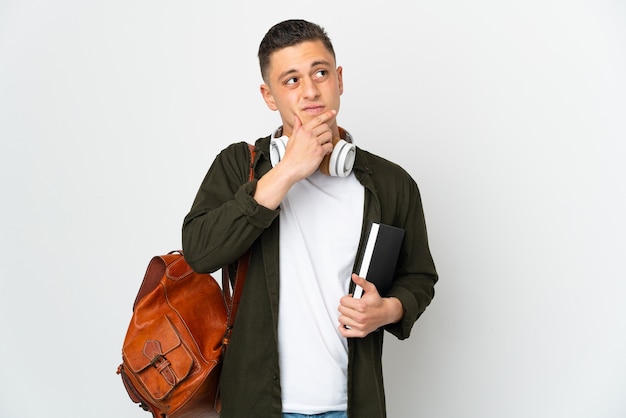 Hombre joven estudiante caucásico aislado teniendo dudas