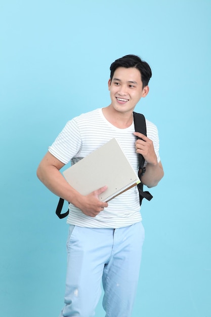 Hombre joven estudiante guapo y alegre asiático aislado en el fondo