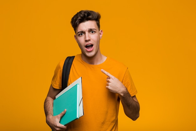 Hombre joven estudiante sosteniendo libros