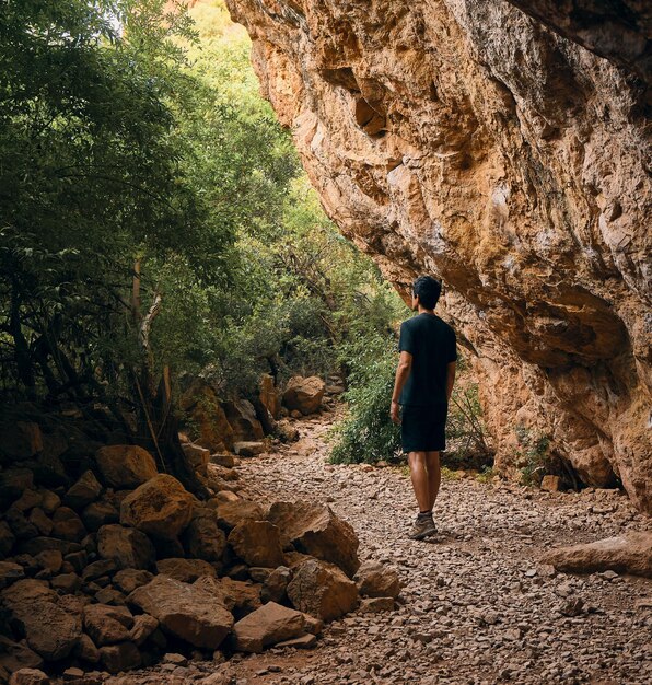 El hombre joven explora la luz de la naturaleza de la cueva