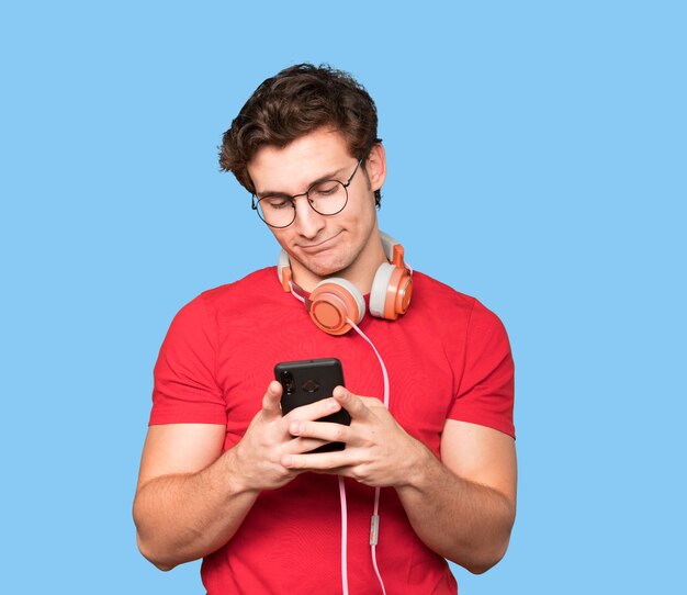 Hombre joven feliz con auriculares y un teléfono inteligente