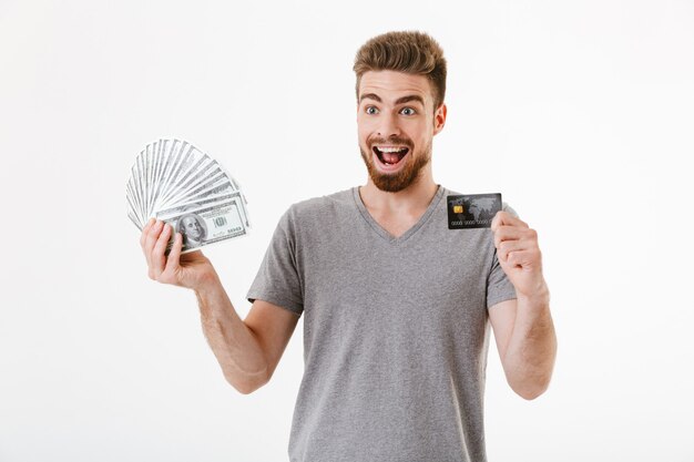 Hombre joven feliz emocionado con dinero y tarjeta de crédito.