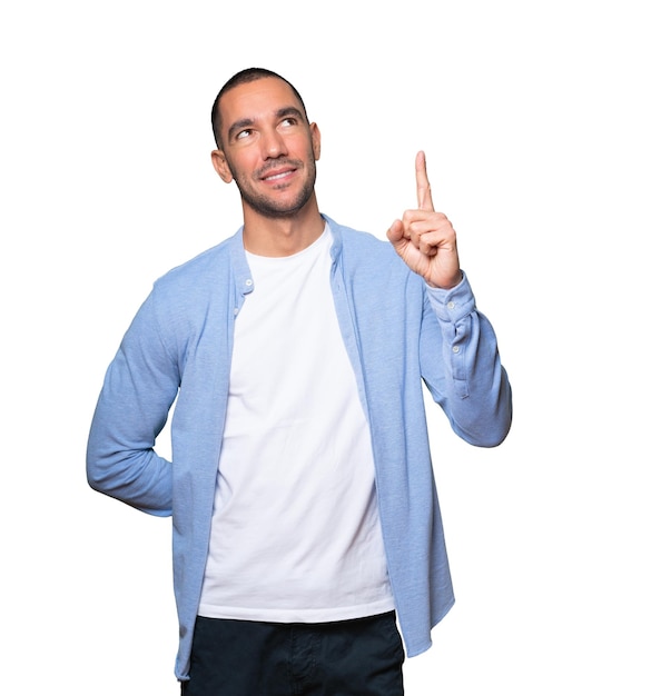 Foto hombre joven feliz que destaca con su dedo