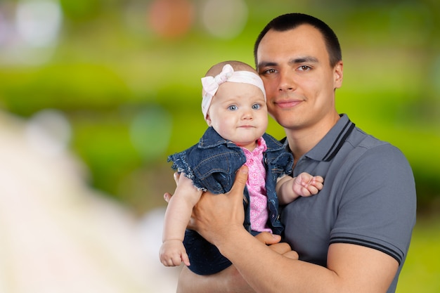 Hombre joven feliz que detiene a un bebé