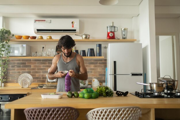 Hombre joven feliz y saludable preparando una comida vegetariana completa en la cocina foto de alta calidad sentirse bien saludable y persona concepto de salud