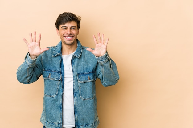 Hombre joven fresco que muestra el número diez con las manos.