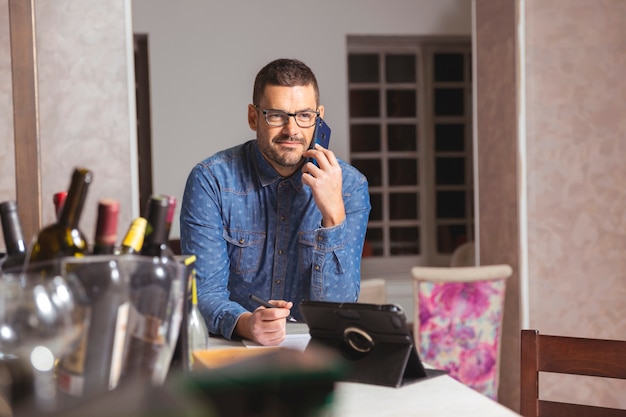 Hombre joven con gafas y camiseta hablando por teléfono