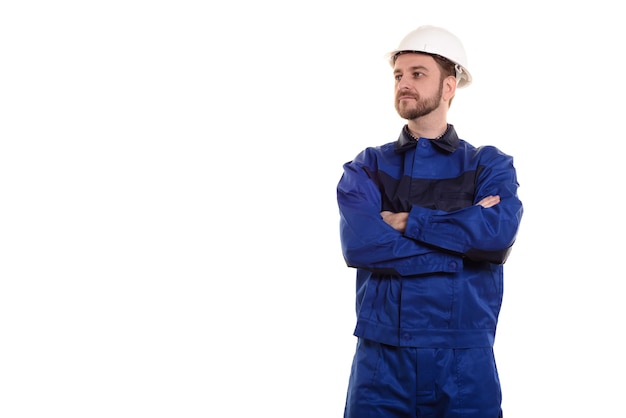 Hombre joven guapo con casco protector en la cabeza y los brazos cruzados