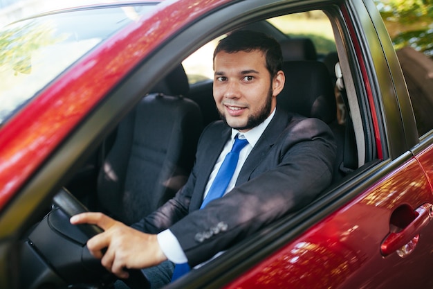 Hombre joven guapo conduciendo un coche