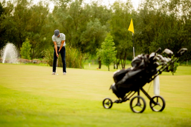 Hombre joven guapo jugando al golf