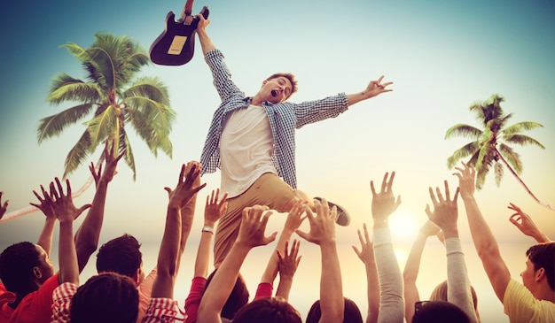 Hombre joven con una guitarra que se realiza en un concierto de la playa