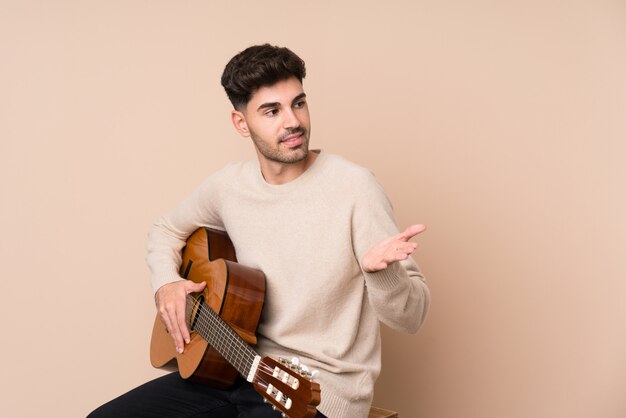 Hombre joven con guitarra sobre aislado con expresión facial sorpresa