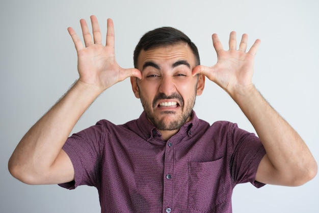 Foto hombre joven haciendo cara fea