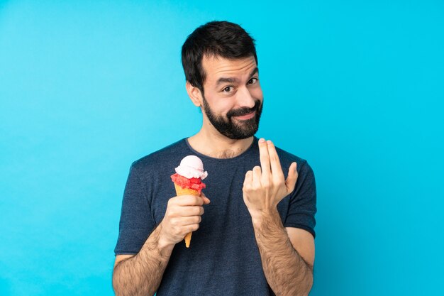 Hombre joven con un helado de cucurucho invitando a venir con la mano. Feliz de que hayas venido