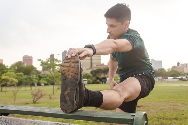 Hombre joven hermoso que se extiende en el parque.