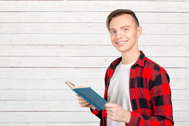 Foto hombre joven hermoso que sostiene los libros