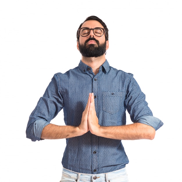 Hombre joven hipster suplicando sobre fondo blanco