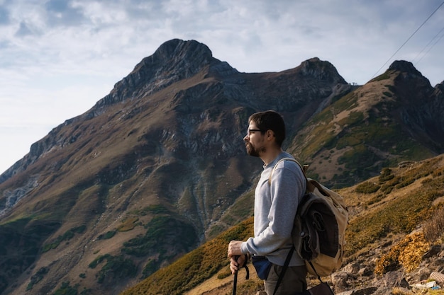 Hombre joven inconformista en las montañas en otoño