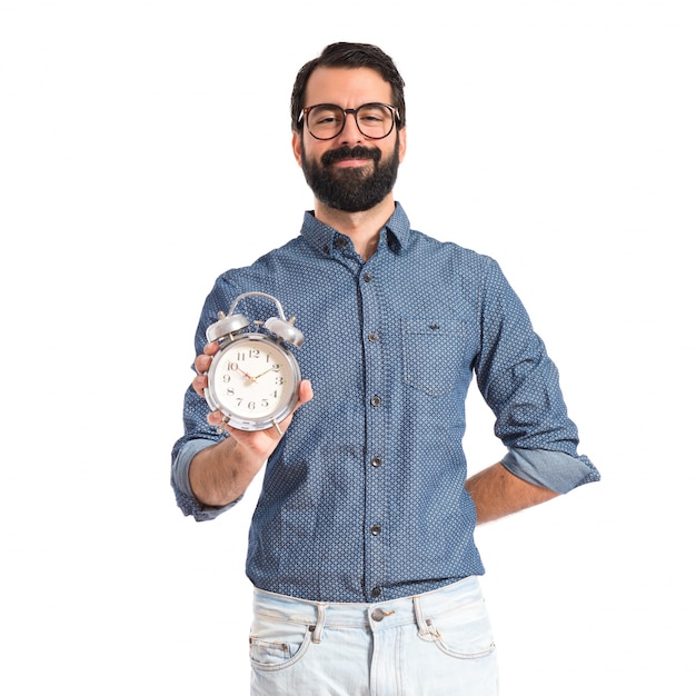 Hombre joven inconformista que sostiene un reloj