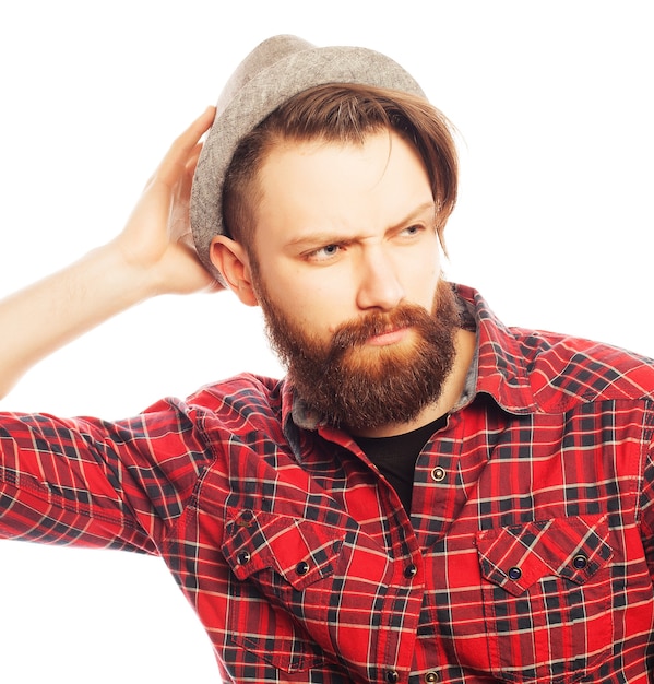 Hombre joven inconformista con sombrero. Foto de estudio sobre fondo blanco.