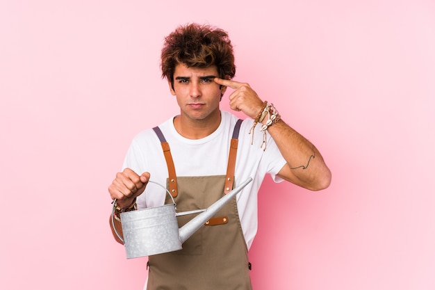 Hombre joven jardinero caucásico aislado mostrando un gesto de decepción con el dedo índice.