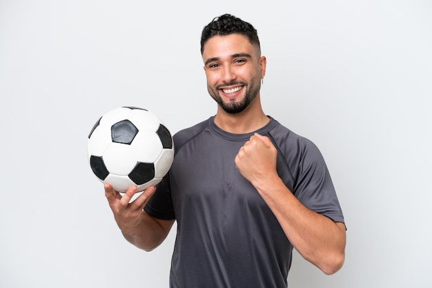 Hombre joven jugador de fútbol árabe aislado sobre fondo blanco celebrando una victoria