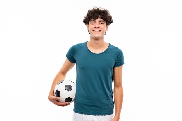 Foto hombre joven del jugador de fútbol sobre la pared blanca aislada que sonríe mucho