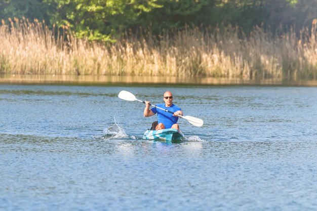 Hombre joven en kayak en el lago. Kayak en el lago.