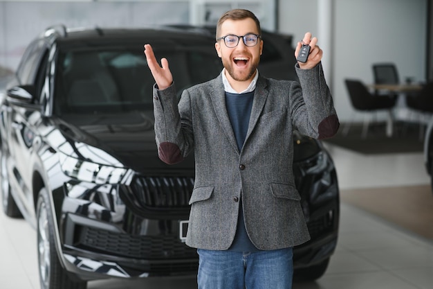 Hombre joven con las llaves en el coche