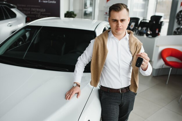 Hombre joven con las llaves en el coche