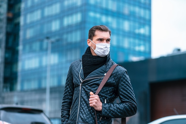 Hombre joven con una máscara protectora de pie en la calle. foto con espacio de copia