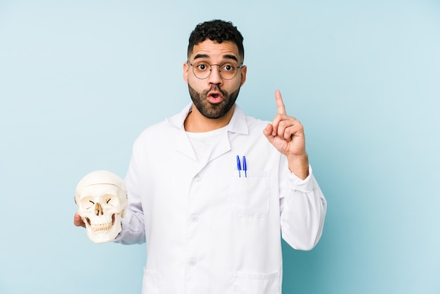 Hombre joven médico sosteniendo una calavera