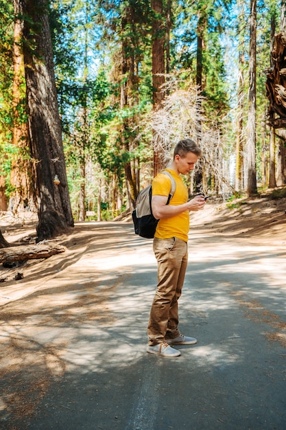 Un hombre joven con una mochila camina en el pintoresco Parque Nacional Sequoia, EE.