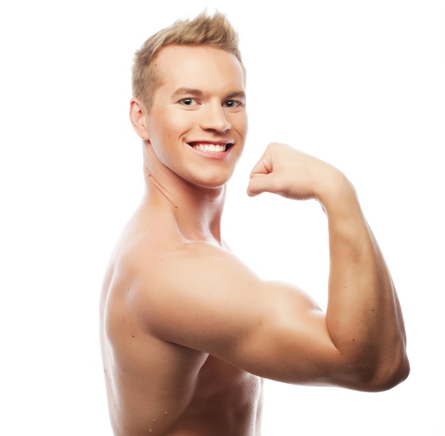 Hombre joven musculoso sano aislado sobre fondo blanco.