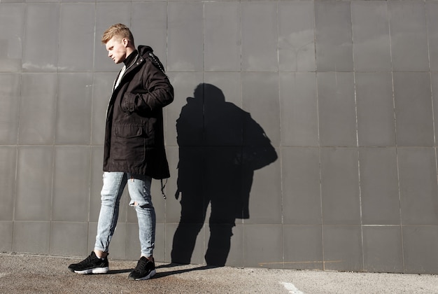 Hombre joven pelirrojo con estilo en traje de moda posando sobre fondo urbano.