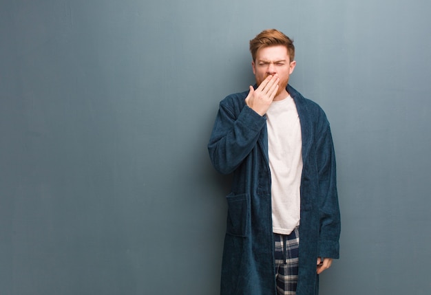 Hombre joven pelirrojo en pijama cansado y con mucho sueño