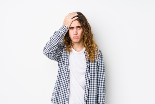 Hombre joven de pelo largo posando aislado siendo sorprendido, ella ha recordado una reunión importante