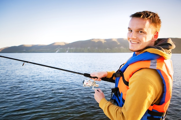 Hombre joven pescando desde un barco