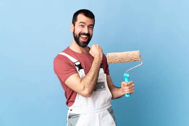 Hombre joven pintor sobre pared aislada