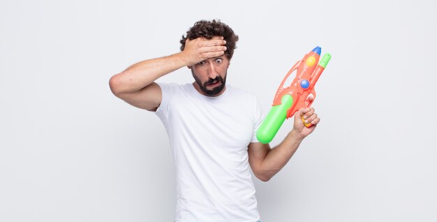 Foto hombre joven con una pistola de agua