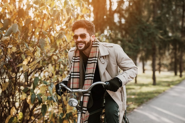 Hombre joven positivo en bicicleta para trabajar.