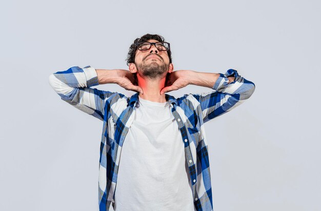 Hombre joven con problemas de hombro y cuello Persona con dolor frotándose el cuello aislado Concepto de personas con problemas de estrés y dolor de cuello Chico cansado con dolor de cuello aislado