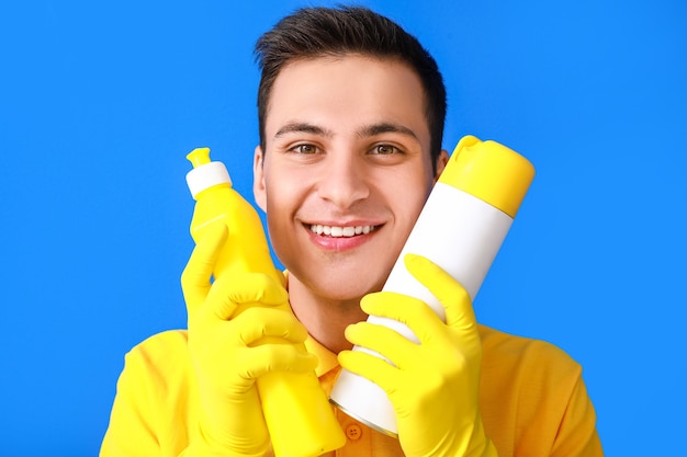 Hombre joven con productos de limpieza en color