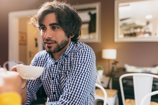 Hombre joven que bebe un té en el café con su novia.