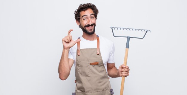 Hombre joven que enmarca o esboza su propia sonrisa con ambas manos, luciendo positivo y feliz, concepto de bienestar