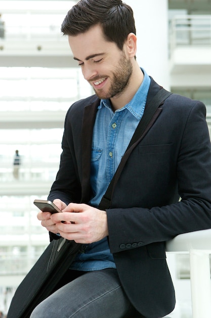 Hombre joven que marca en el teléfono móvil